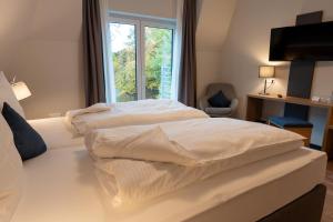 RuppertsweilerHotel-Landgasthaus Ständenhof的配有窗户的酒店客房内的两张床
