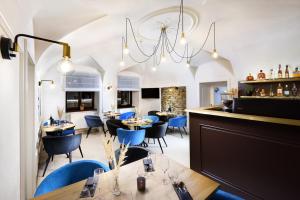 波普拉德Kalix Boutique Hotel的餐厅设有蓝色的桌椅和吊灯。