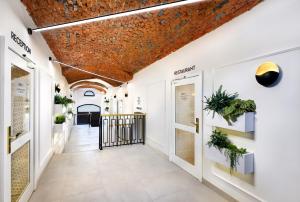 波普拉德Kalix Boutique Hotel的拥有白色墙壁和砖砌天花板的走廊