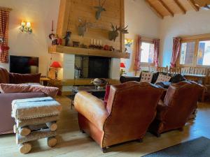梅杰夫Chalet Roseau的客厅配有皮革家具和壁炉