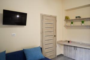 利沃夫Aquamarine apartments Lviv的客厅配有蓝色的沙发和平面电视。