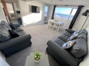 布里德灵顿Bridlington Bay Apartments的一间带两张沙发的客厅和一间带一张桌子的用餐室