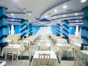 维利波吉Hotel Lakaj的一间设有白色桌椅的用餐室