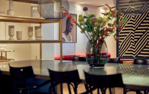 阿姆斯特丹阿姆斯特丹姆金普顿德威特酒店的用餐室,配有一张桌子和花瓶