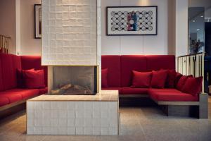 阿姆斯特丹阿姆斯特丹姆金普顿德威特酒店的客厅设有红色的沙发和壁炉