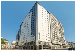 库里提巴Bourbon Curitiba Hotel & Suítes的一条城市街道上高大的白色建筑