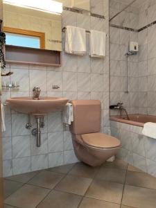 塔什St Martin Apartments的浴室配有卫生间、盥洗盆和浴缸。