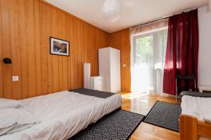 克雷尼察Krynica Zamkowa 48的一间卧室设有一张床和一个大窗户