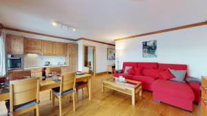 韦松纳Hauts de Veysonnaz SAUNA & VIEW apartments的客厅配有红色的沙发和桌子