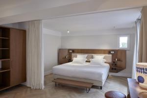 巴黎Hôtel du Sentier的一间卧室配有带白色床单和白色枕头的床。