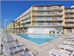 富丽海滩115 Charleston Oceanfront Villas Beach Daze的大型酒店,设有游泳池和躺椅