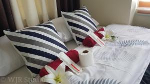 马尼拉Anuva Deluxe Couple Suite的一张带枕头和毛巾的白色床