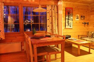 埃农泰基厄欧纳斯洛玛奢华小屋的木制用餐室设有桌子和窗户