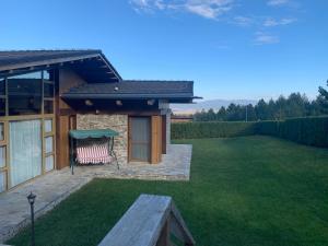 班斯科Pirin Golf Villa Emila的庭院内带长凳的草坪房子