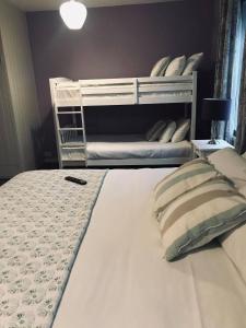 皮克林White Horse Farm Inn的卧室配有带枕头的白色双层床