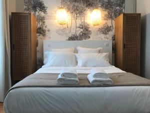拉罗谢尔Maison Caju - La Rochelle的一间卧室配有一张床,上面有两条毛巾