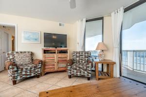 富丽海滩220 Charleston Oceanfront Villas Dolphin View的客厅配有2把椅子和平面电视