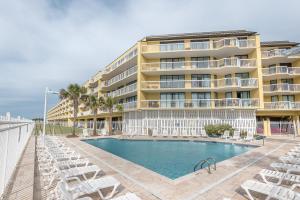 富丽海滩220 Charleston Oceanfront Villas Dolphin View的一座带游泳池和椅子的酒店和一座建筑