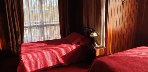 蓬塔阿雷纳斯La Casa Guesthouse的一间卧室设有两张靠窗的床。
