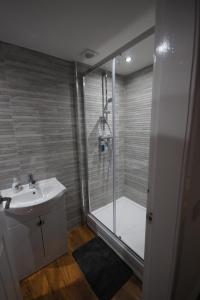 德里门Loch Lomond Riverside Apartment的带淋浴和白色盥洗盆的浴室