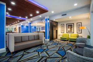 德兰Holiday Inn Express & Suites - Deland South, an IHG Hotel的大堂配有沙发和椅子