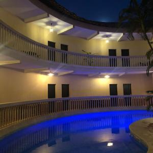 济金绍尔LES JARDINS DU FLAMBOYANT的大楼内带蓝色灯光的大型游泳池