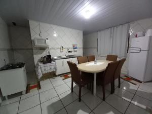 伊瓜苏Sobrado 02 quartos próx. Hotel Recanto Cataratas的厨房配有桌椅和冰箱。