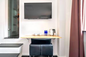 汉诺威威甘德设计酒店的一张小桌子,椅子和墙上的电视