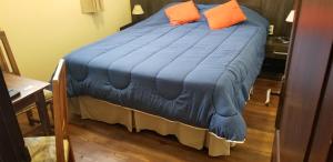 特立尼达岛Hotel Trinidad的一张蓝色的床,上面有两个橙色枕头