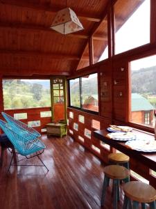 伊萨La Sarita, Hospedaje rural.的客房设有桌椅和窗户。