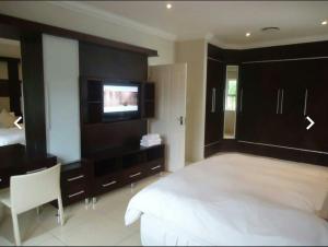 爱德华港Caribbean Estates: Barbados No. 12的一间卧室配有一张大床和一台平面电视
