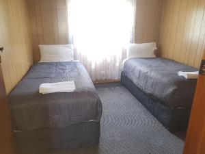 芒特甘比尔Limestone Coast Tourist Park的小型客房 - 带2张床和窗户