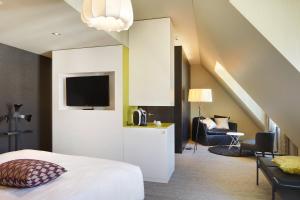 卢塞恩大陆公园酒店的一间卧室配有一张床、电视和椅子