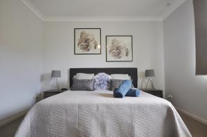 贝尔拉拉Sandy Toes的卧室配有带蓝色枕头的大型白色床