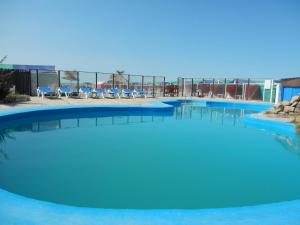 圣克拉拉德尔马尔Hotel Central park的一座蓝色海水和椅子的大型游泳池