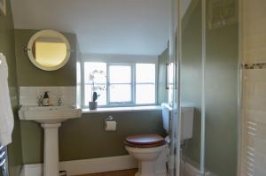 水上伯顿Darly Cottage的一间带卫生间、水槽和窗户的浴室