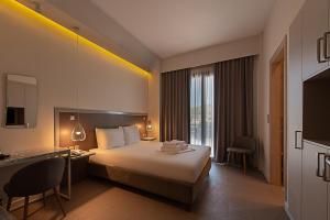 纳夫普利翁Avra Nafpliou的酒店客房设有一张大床和一张书桌。