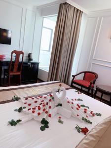 岘港Khanh Linh Hotel的酒店客房的床铺上摆放着玫瑰花
