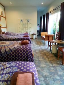 Muang Suanghomestay568 Branch 2的酒店客房带两张床和一张桌子以及椅子。