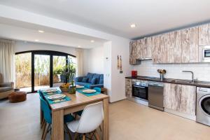 米哈斯Beach Pearl Cala de Mijas的厨房以及带桌椅的起居室。