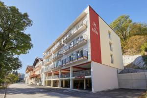 格拉茨I AM HOTEL Graz-Seiersberg的公寓大楼拥有红色和白色的外墙