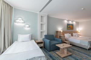 阳光海滩乐朋海滩酒店的酒店客房,设有两张床和一张蓝色椅子