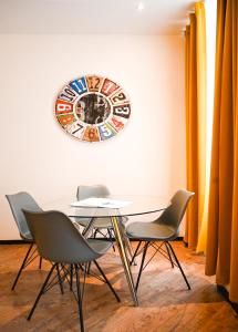 维也纳Elegant Apartment Westbahnhof的桌子、椅子和墙上的时钟