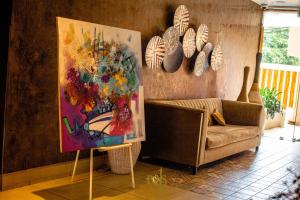 阿比让Roots Hotel Apartments Abidjan的客厅配有绘画和沙发