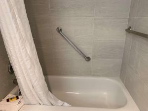 阿伯茨福德贝斯特韦斯特高级丽晶酒店及会议中心的浴室内设有带浴帘的白色浴缸