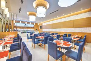 迪拜杜拜阿尔库利因布尔酒店的一间配备有桌子和蓝色椅子的用餐室