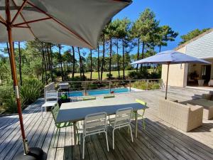 拉卡诺Villa les Mimosas with pool and fantastic views的庭院配有桌椅和遮阳伞。