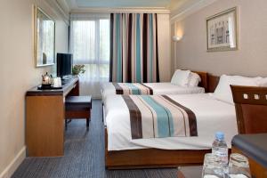 里尔欧洲里尔装饰艺术酒店的酒店客房配有两张床和一张书桌