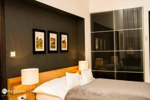 奥拉迪亚Ivana Apart Hotel的卧室配有一张床,墙上有三幅照片