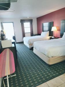 AlvaRanger Inn Alva的酒店客房设有两张床和红色的墙壁。